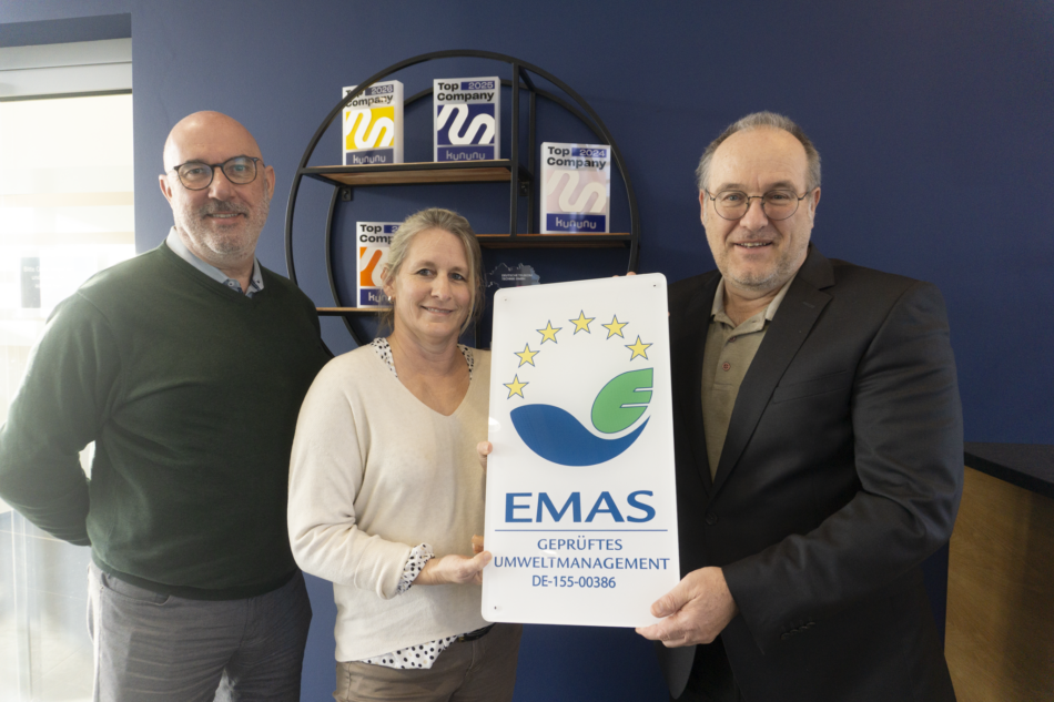 Kaufmännischer Leiter Tobias Kohlmeyer, Diplom Kauffrau Susanne Kneißl-Heinevetter von der IHK München und Umweltbeauftragter Dieter Pollok bei der Übrgabe des EMAS-Türschilds