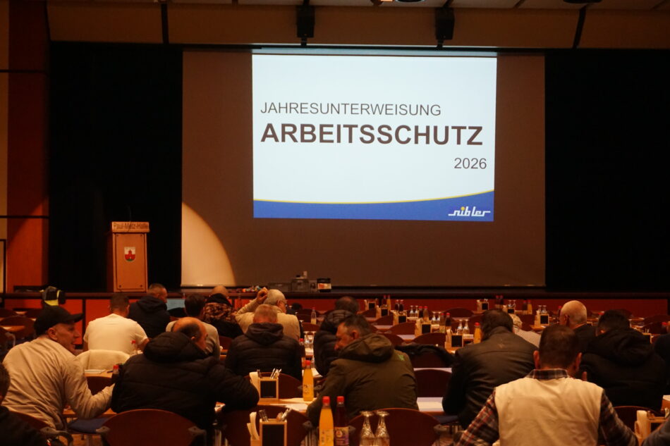 Einige MItarbeiter sind schon in der Paul Metz Halle versammelt und warten auf den Beginn des Vortrags der Jahresunterweisung Arbeitsschutz 2026